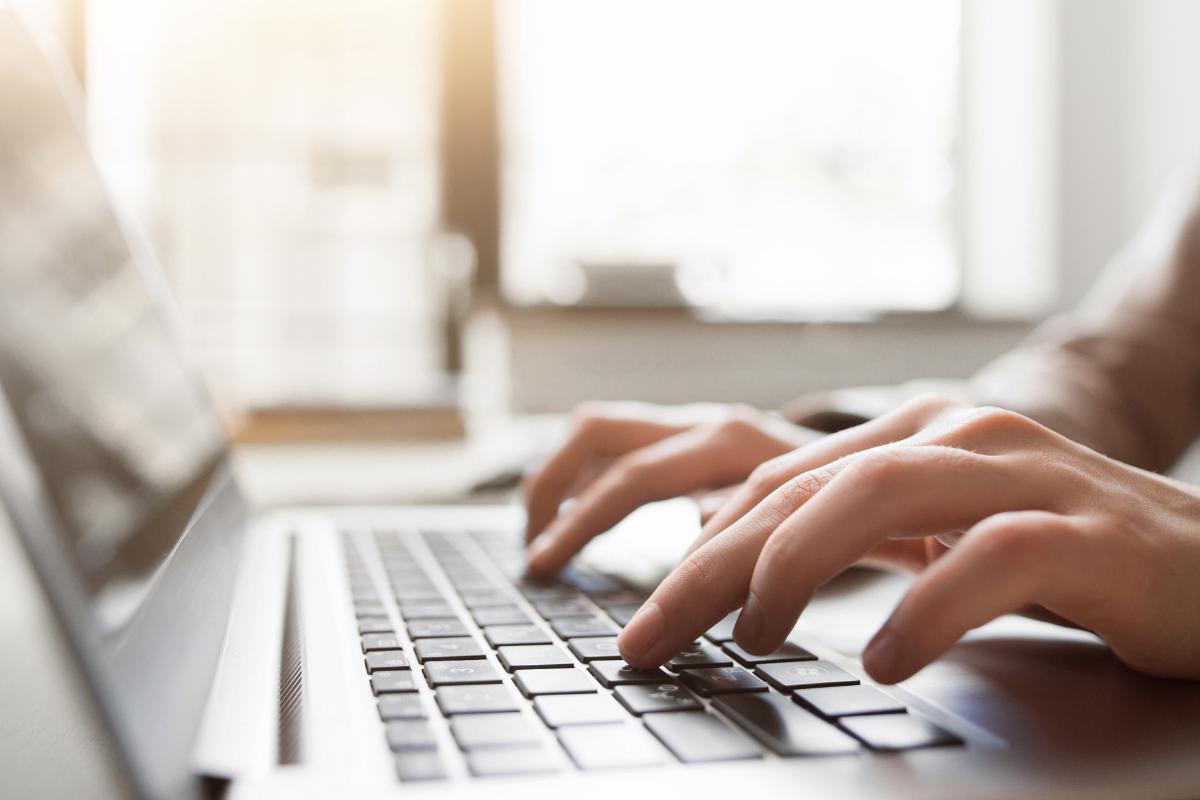 a woman sits at her laptop perfecting her cover letter before sending it to potential job opportunities