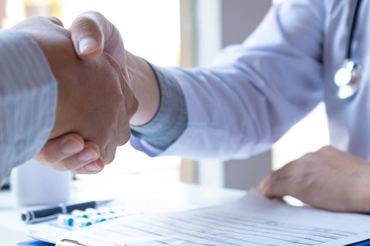 two people handshake as one lands a healthcare job in california