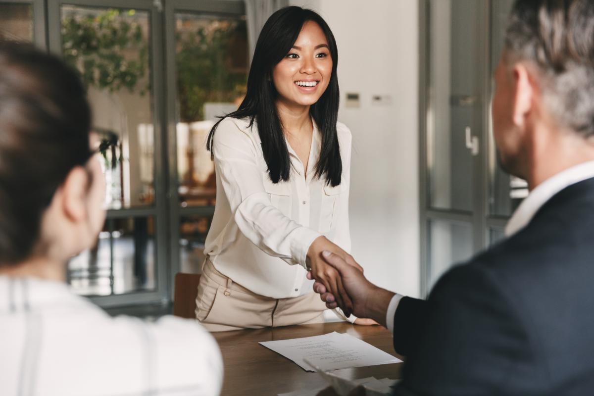 a person shakes anothers hand during a job interview possibly for one of many clinical health jobs