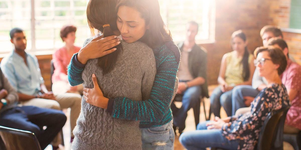 a group of people hug in one of the outpatient programs in houston