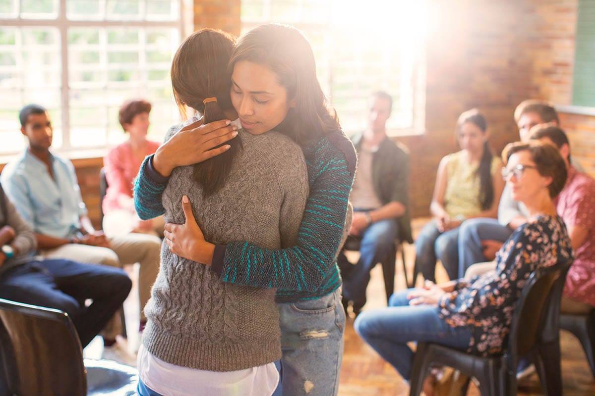 a group of people hug in one of the outpatient programs in houston