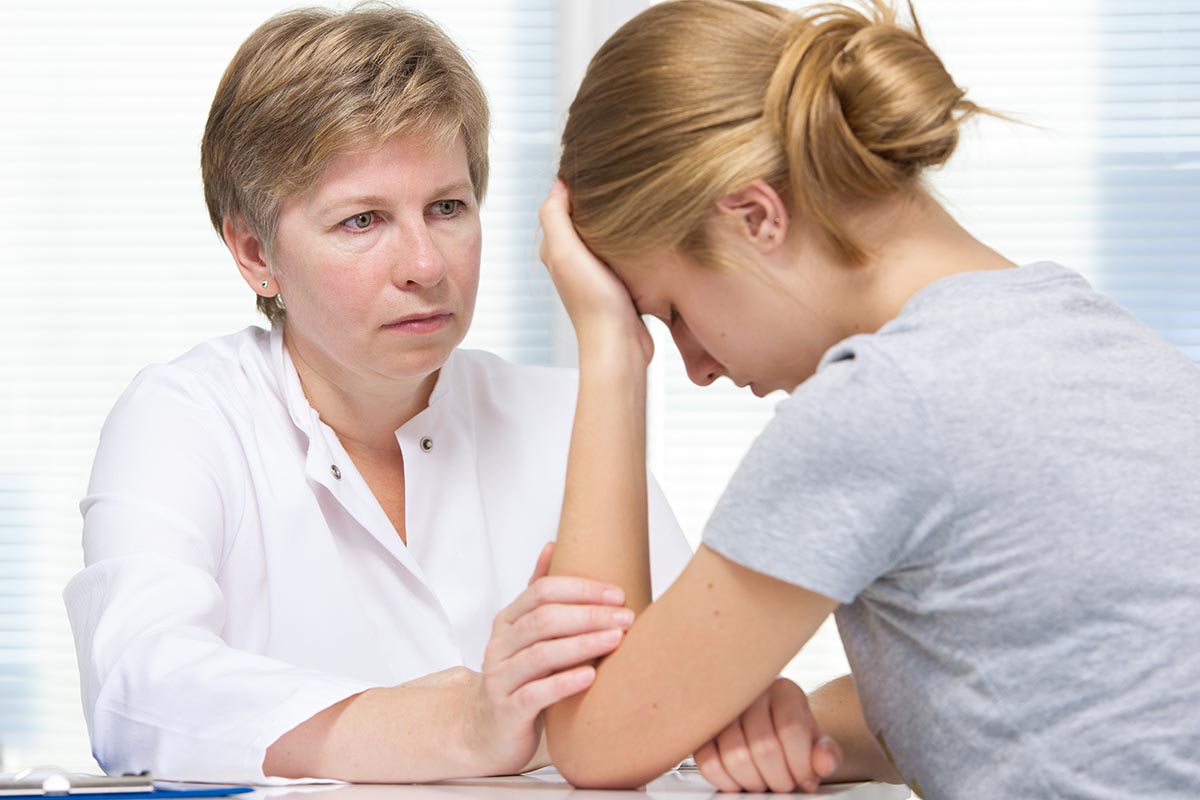 a person comforts a teen after recognizing the link between teens and heroin