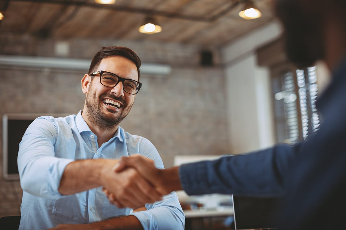 a person shakes hands with another after discussing contract work vs freelance