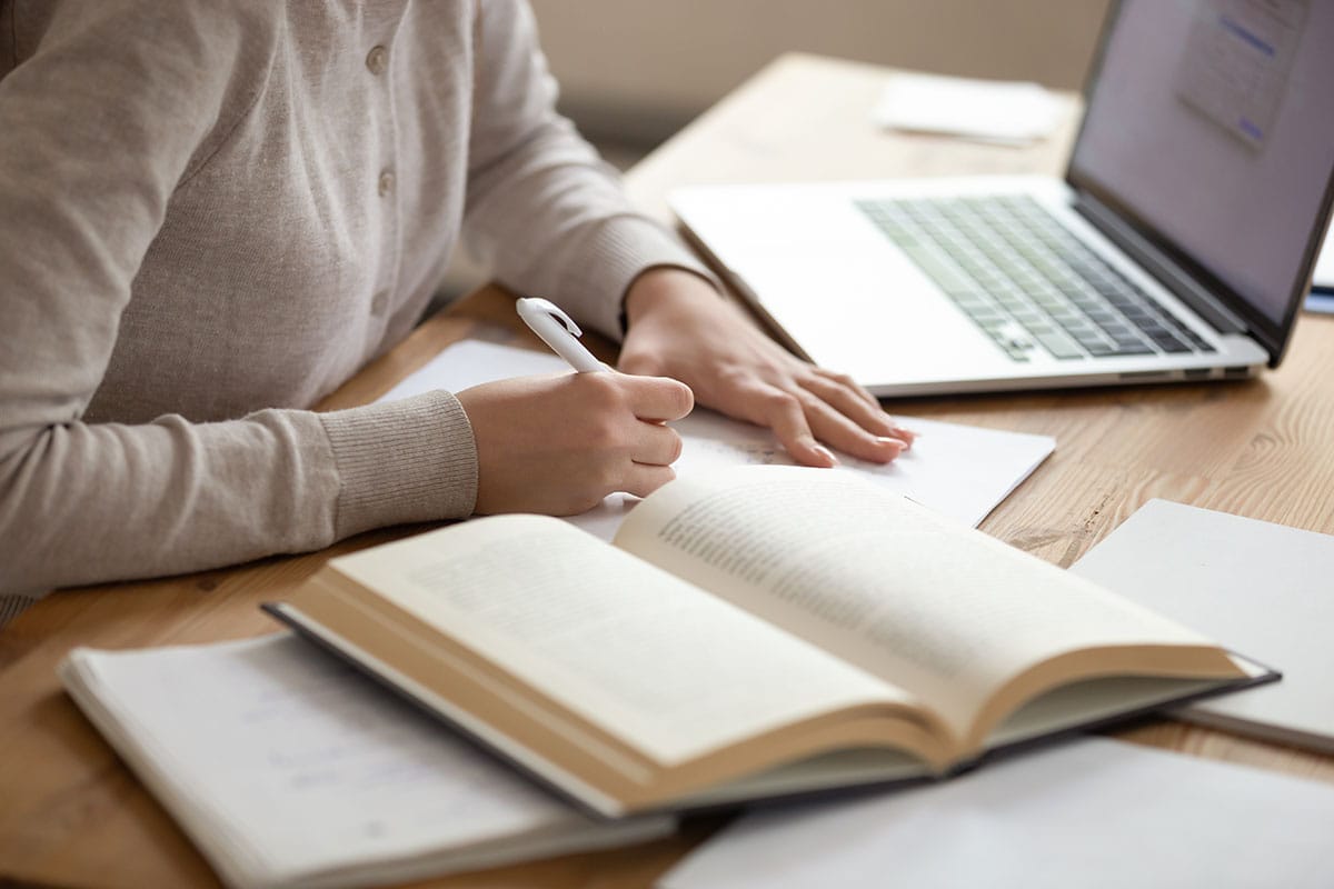 a person takes notes from a book on how to become a psychiatrist