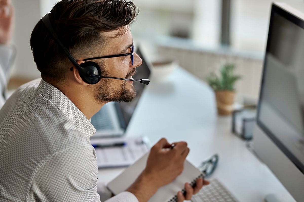 a person with a headset works in case management on a computer