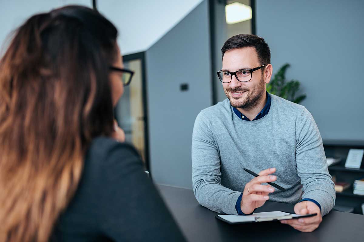 a man interviews a prospective candidate for a job in the behavioral health field who wishes to switch careers