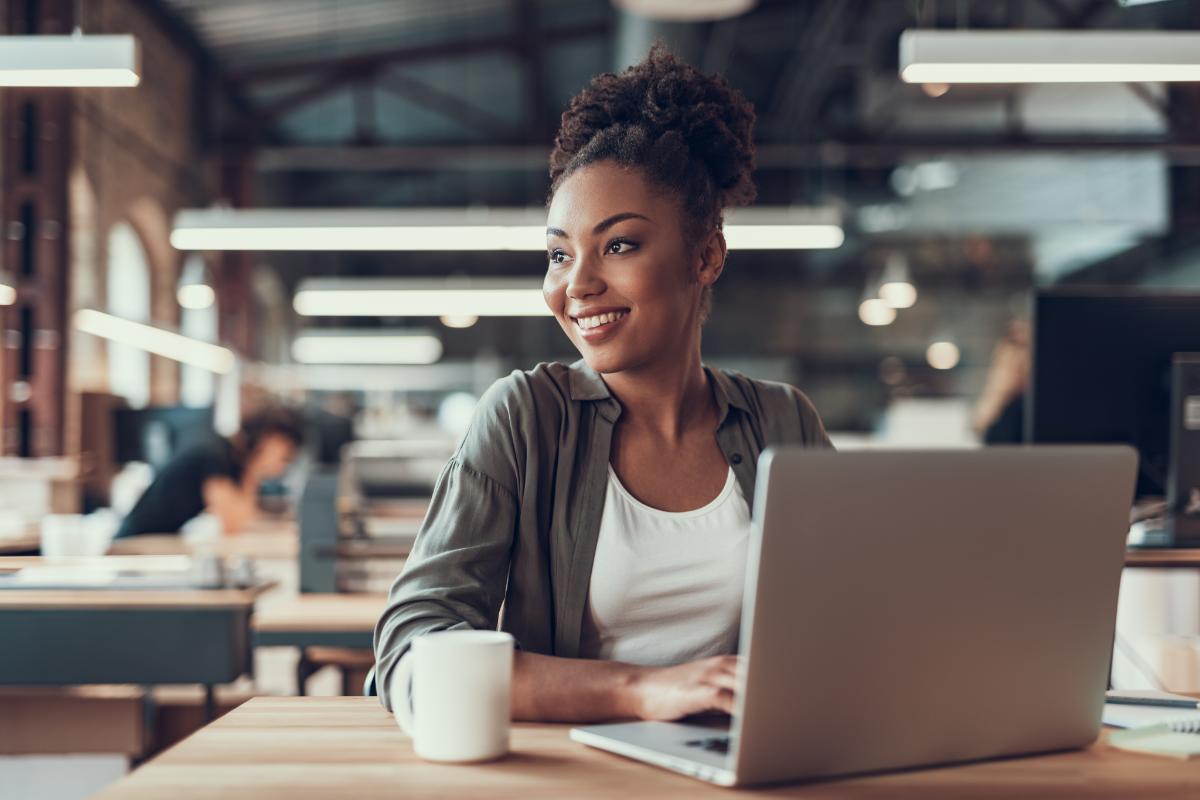 a young woman has an easy and happy time adjusting to life back in the office after working remotely for a while