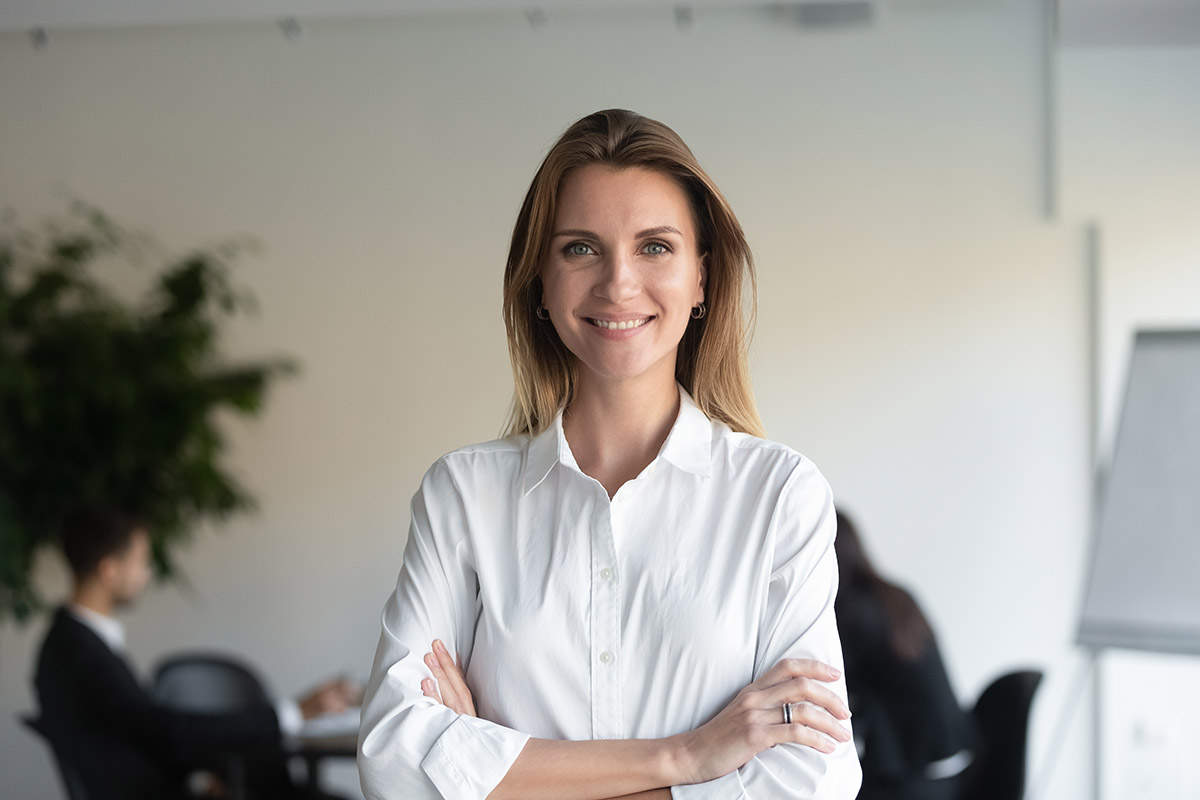 a woman stands in the office where she works as a healthcare program manager