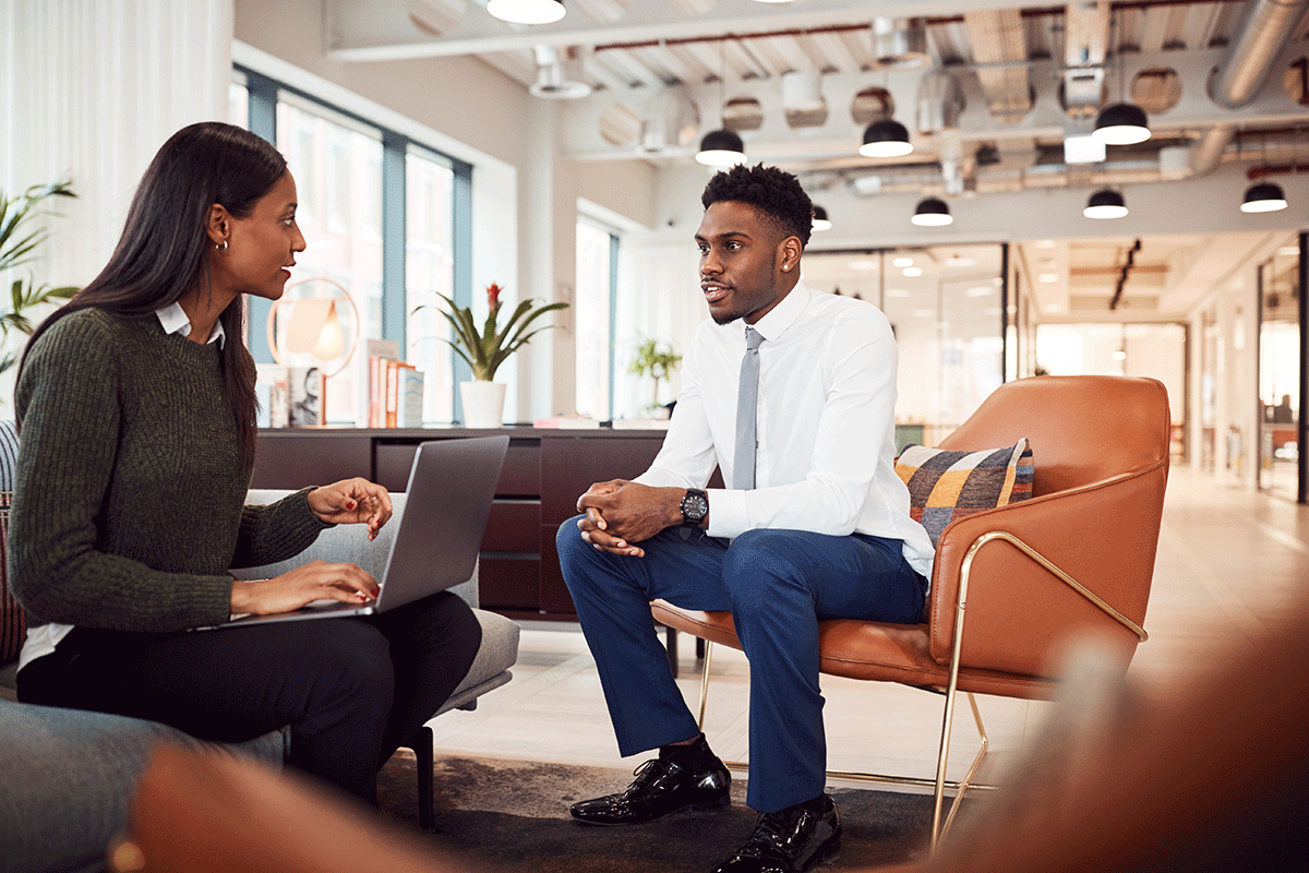 a young man confidently negotiates his salary with his employer