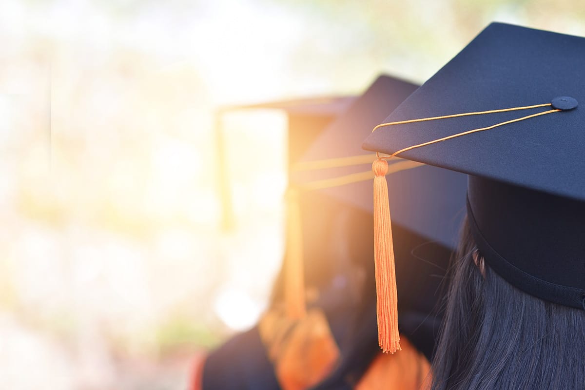 college graduates line up to receive their diplomas at graduation