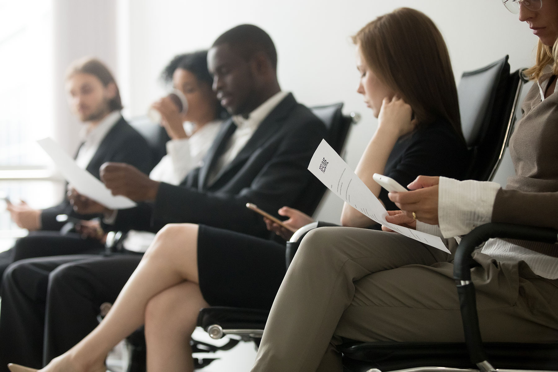 a group of hopeful applicants wait to interview for an office job