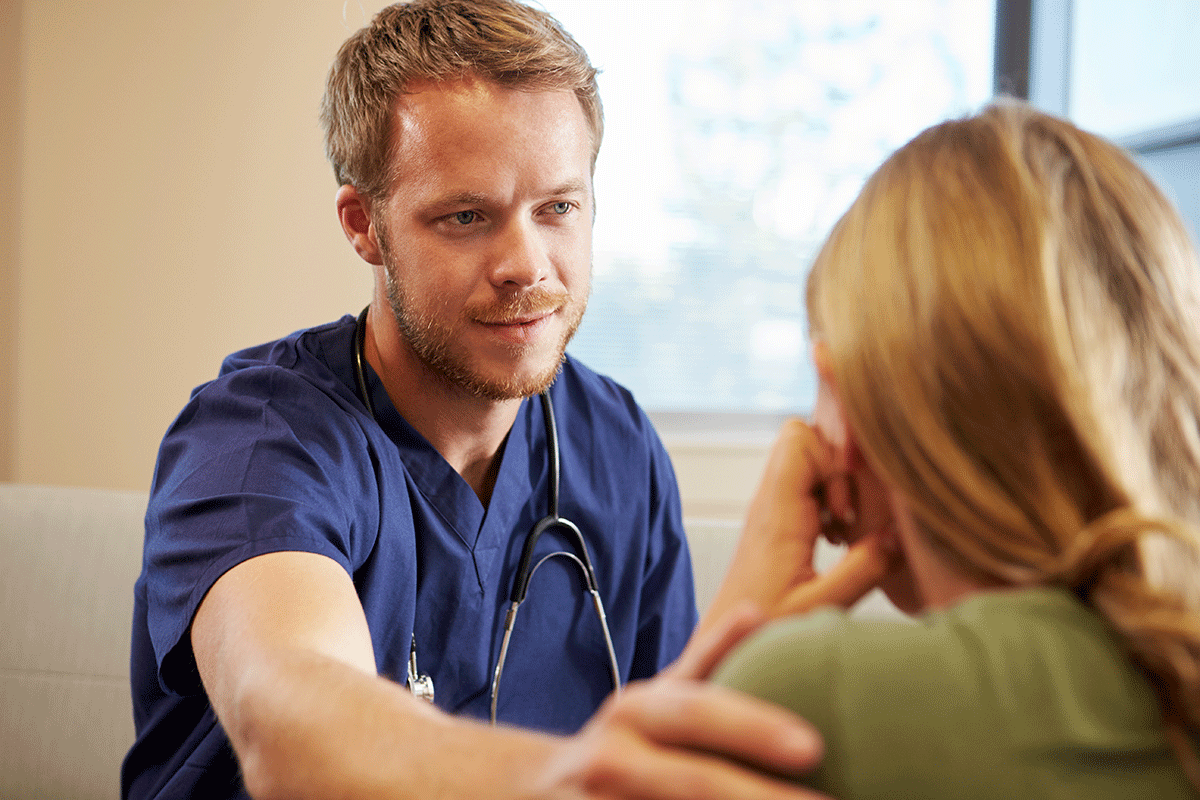 a behavioral health nurse comforts a patient in distress